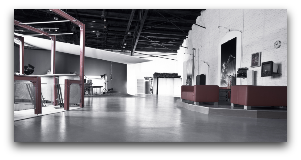 Industrieller Loungebereich im Mietstudio von Arts Unlimited 4 Rent mit roten Sofas, Kunstwerken und Studioequipment