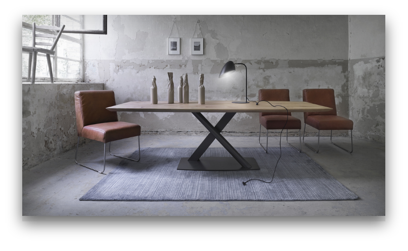 „Industrieller Raum im Studio von Arts Unlimited 4Rent mit Holztisch, Lederstühlen und Betonwand“